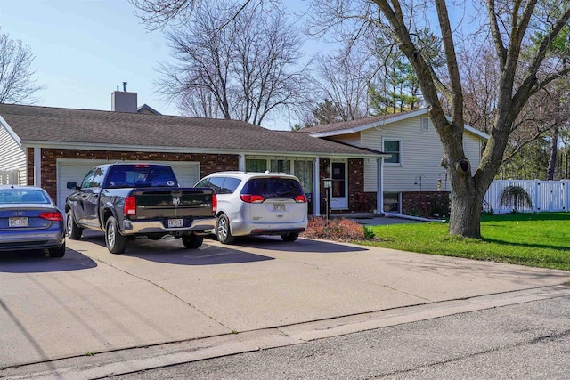 2005 Hollister Ave, Tomah, WI 54660 - tri-level home with a chimney, a front yard, a garage, brick siding, and fence