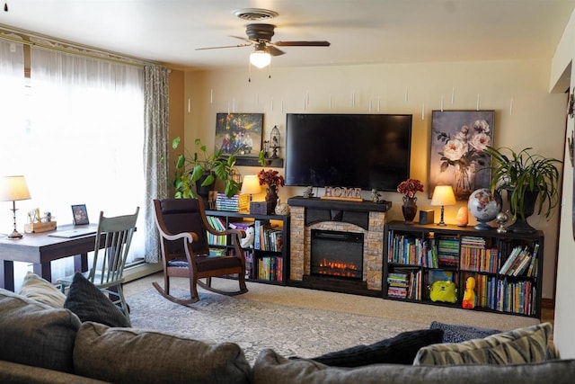 2005 Hollister Ave, Tomah, WI 54660 - living area with ceiling fan, visible vents, a stone fireplace, and carpet