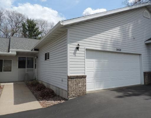 view of side of property with aphalt driveway and a garage