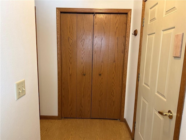 hall with baseboards and light wood-type flooring