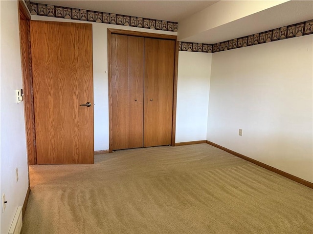 unfurnished bedroom with a closet, carpet, and baseboards