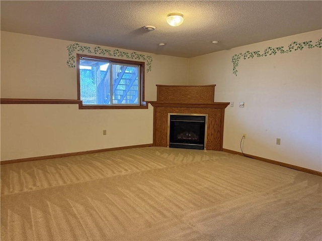 unfurnished living room with a fireplace, baseboards, light carpet, and a textured ceiling
