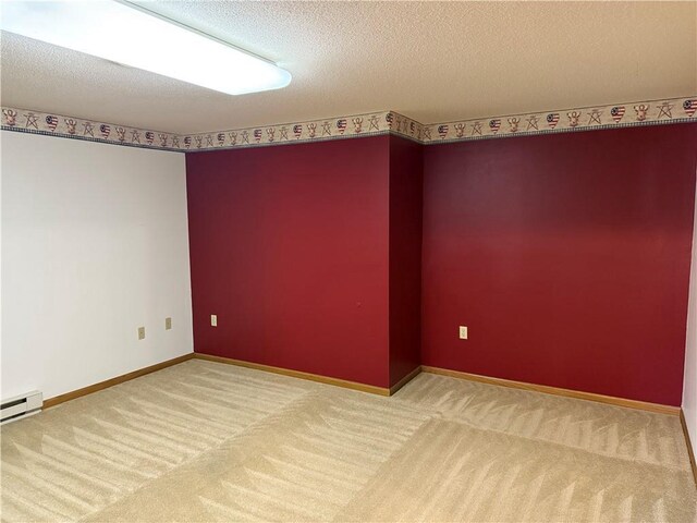 spare room featuring baseboards, carpet flooring, and a textured ceiling