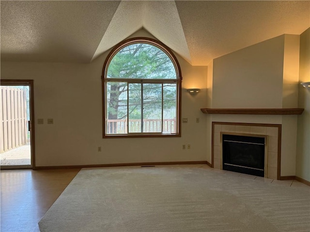unfurnished living room with plenty of natural light, a textured ceiling, and lofted ceiling