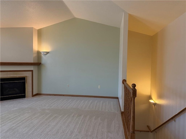 unfurnished living room featuring carpet floors, baseboards, a fireplace, and vaulted ceiling
