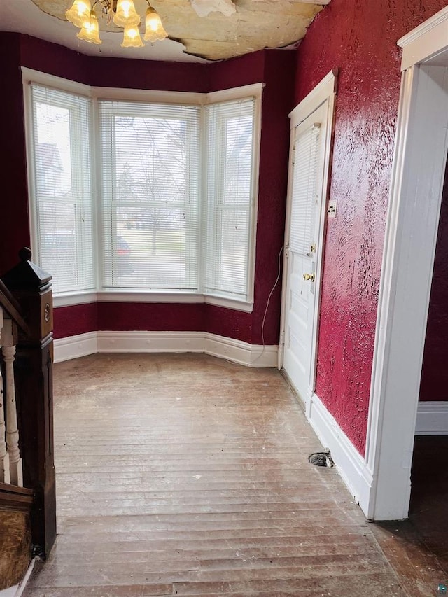 2002 Banks Ave, Superior, WI 54880 - unfurnished dining area featuring wood finished floors, a chandelier, and baseboards