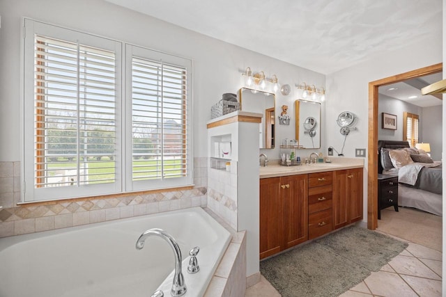 ensuite bathroom with a bath, a sink, and plenty of natural light