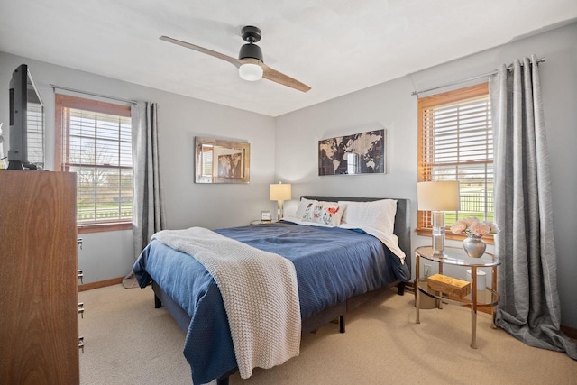 carpeted bedroom featuring baseboards, a ceiling fan, and multiple windows
