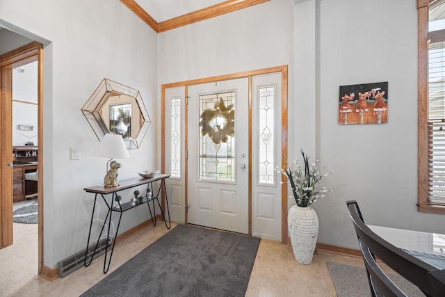 entrance foyer featuring a towering ceiling, ornamental molding, and baseboards