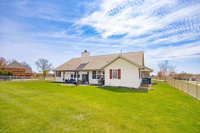 rear view of property with a patio, a yard, and a fenced backyard