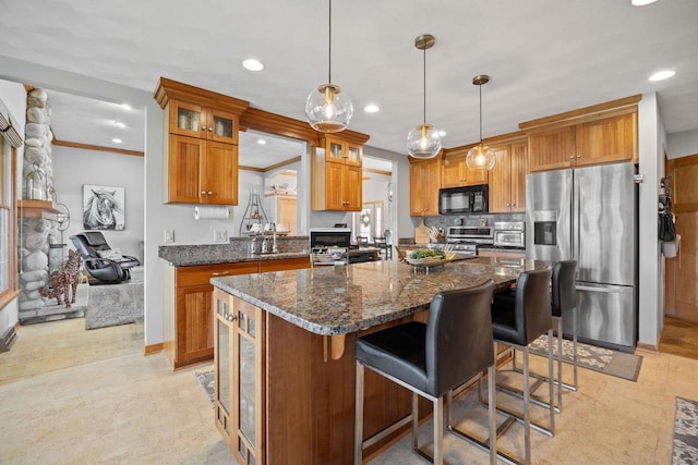 kitchen with brown cabinets, glass insert cabinets, appliances with stainless steel finishes, a kitchen island, and recessed lighting
