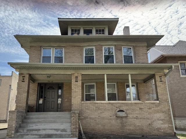 traditional style home featuring covered porch and brick siding