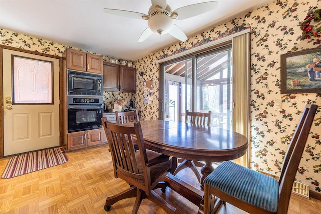 dining room with wallpapered walls and a ceiling fan