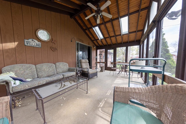 sunroom featuring beamed ceiling, ceiling fan, outdoor lounge area, and outdoor dining area