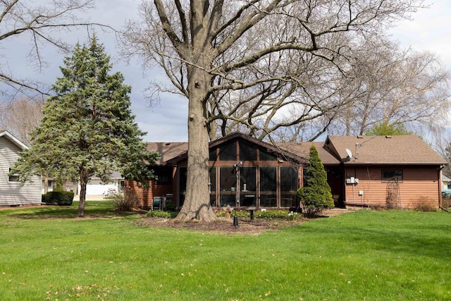 back of house featuring a yard and a sunroom