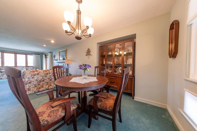 dining area featuring a chandelier, baseboards, and dark carpet