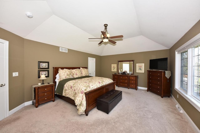 bedroom with visible vents, a ceiling fan, vaulted ceiling, and light carpet