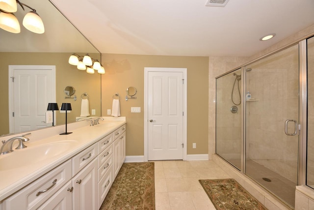 bathroom featuring double vanity, a sink, baseboards, and a shower stall