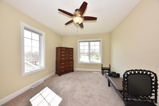 living area featuring a ceiling fan, baseboards, visible vents, and carpet