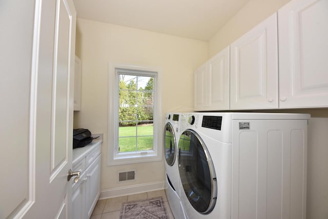 washroom with visible vents, cabinet space, baseboards, separate washer and dryer, and light tile patterned flooring