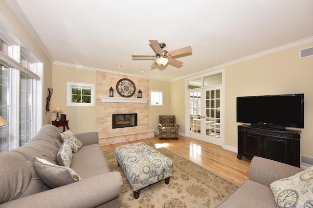 living room with ornamental molding, ceiling fan, wood finished floors, and a healthy amount of sunlight