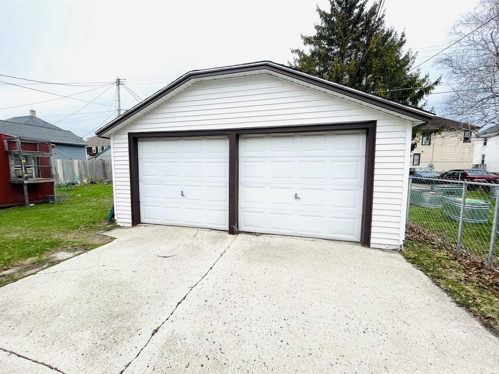 detached garage featuring fence