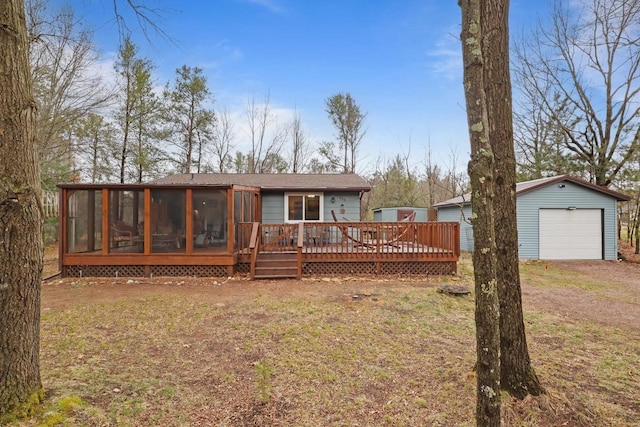 996 Inverness Ct, Nekoosa, WI 54457 - back of property featuring a sunroom, a detached garage, dirt driveway, a deck, and an outbuilding