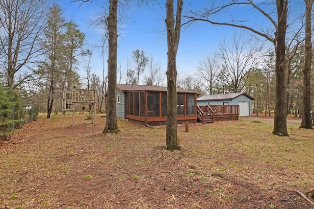 996 Inverness Ct, Nekoosa, WI 54457 - rear view of house with a sunroom, a deck, a detached garage, and an outdoor structure