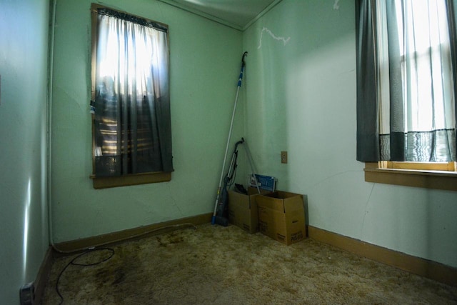 carpeted empty room featuring baseboards