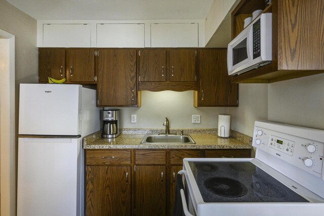 229 N Ludington St, Columbus, WI 53925 - kitchen featuring white appliances, a sink, and light countertops