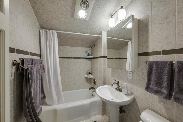 229 N Ludington St, Columbus, WI 53925 - full bathroom featuring tile walls, decorative backsplash, shower / bath combo with shower curtain, and toilet