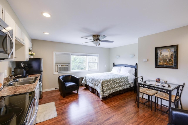 229 N Ludington St, Columbus, WI 53925 - bedroom featuring radiator heating unit, dark wood-style floors, recessed lighting, cooling unit, and a sink