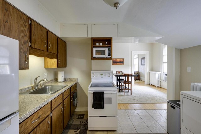 229 N Ludington St, Columbus, WI 53925 - kitchen featuring brown cabinets, a sink, white appliances, light countertops, and radiator