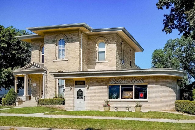 229 N Ludington St, Columbus, WI 53925 - view of front of house with a front lawn and brick siding