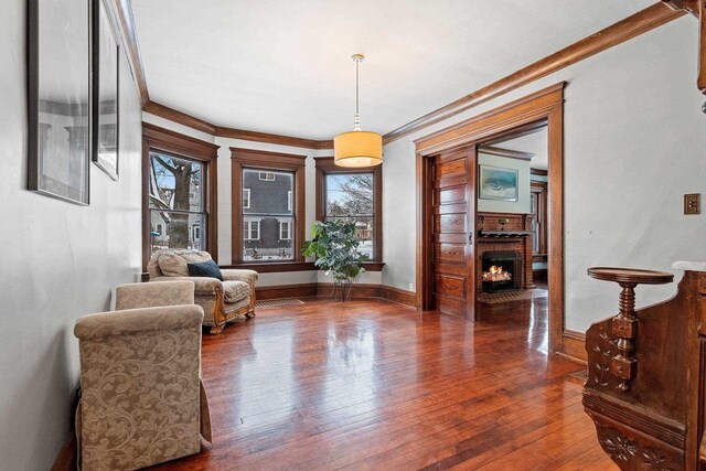 745 S Quincy St, Green Bay, WI 54301 - living area with a brick fireplace, plenty of natural light, ornamental molding, and wood-type flooring