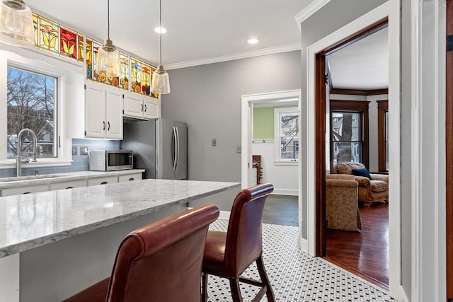 745 S Quincy St, Green Bay, WI 54301 - kitchen with a sink, white cabinetry, ornamental molding, hanging light fixtures, and appliances with stainless steel finishes