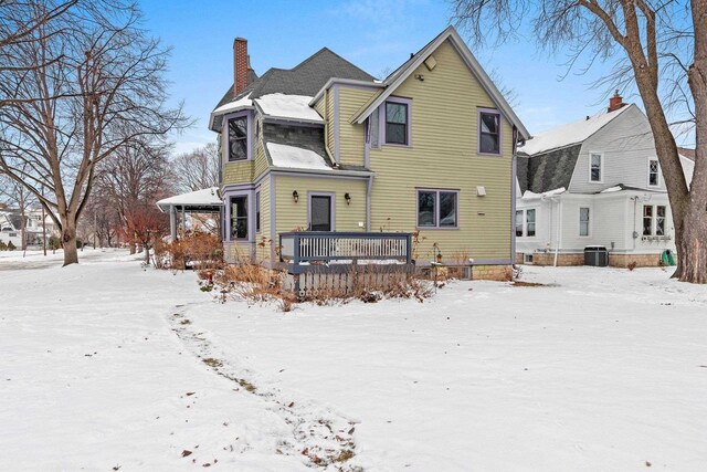 745 S Quincy St, Green Bay, WI 54301 - snow covered rear of property with a chimney, a wooden deck, and central AC