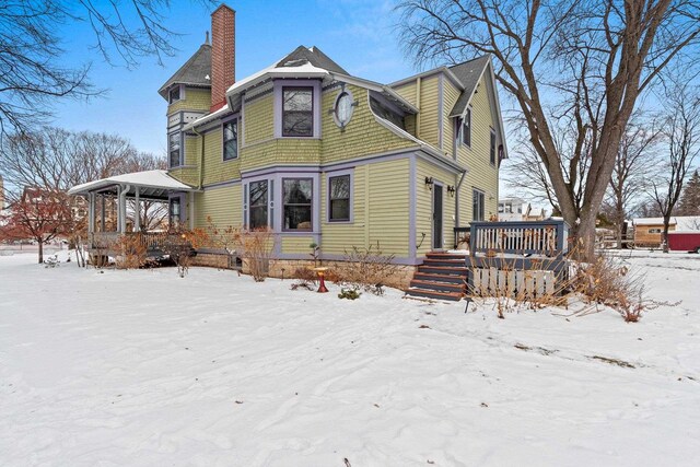 745 S Quincy St, Green Bay, WI 54301 - snow covered back of property with a wooden deck and a chimney