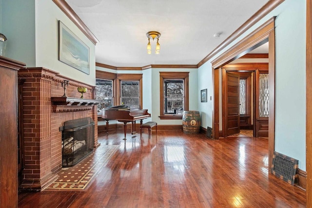 745 S Quincy St, Green Bay, WI 54301 - living area featuring hardwood / wood-style flooring, crown molding, visible vents, baseboards, and a brick fireplace