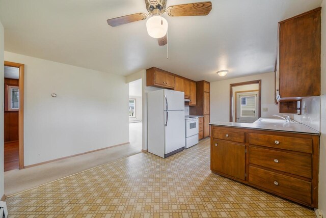 167 Gwynn St, Green Bay, WI 54301 - kitchen featuring white appliances, brown cabinetry, ceiling fan, a sink, and baseboards