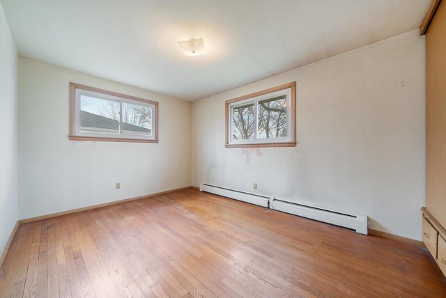 167 Gwynn St, Green Bay, WI 54301 - unfurnished room with a wealth of natural light, light wood-style flooring, a baseboard heating unit, and baseboards