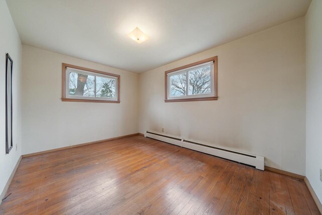 167 Gwynn St, Green Bay, WI 54301 - unfurnished room featuring hardwood / wood-style flooring, baseboard heating, and baseboards