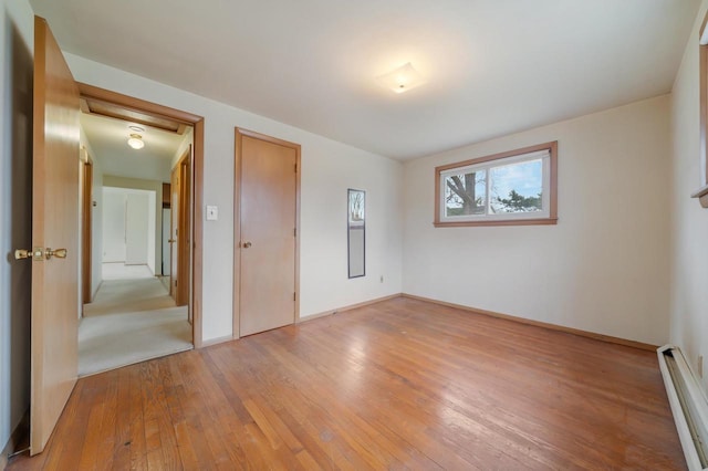 167 Gwynn St, Green Bay, WI 54301 - unfurnished bedroom featuring baseboards, light wood-style flooring, and a baseboard radiator