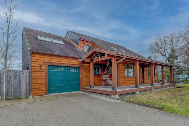 N7315 Winnebago Dr, Fond Du Lac, WI 54935 - chalet / cabin with a garage, covered porch, roof with shingles, log veneer siding, and fence