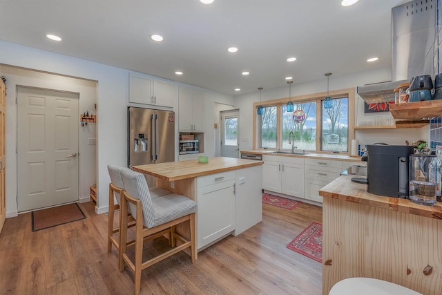N7315 Winnebago Dr, Fond Du Lac, WI 54935 - kitchen with butcher block counters, a sink, high end fridge, light wood-style flooring, and white cabinetry