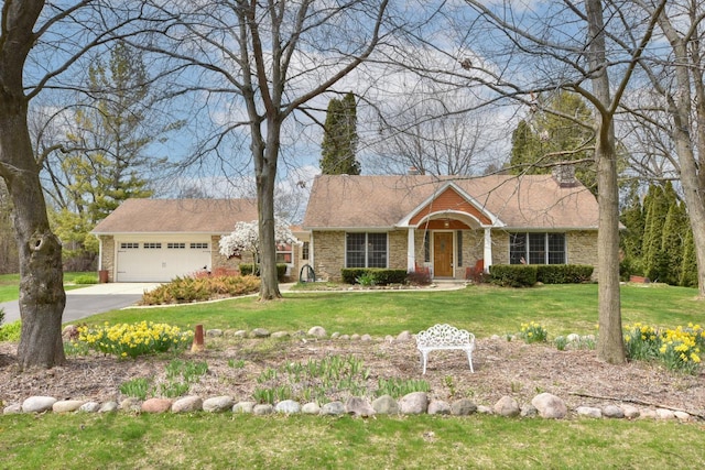 ranch-style house featuring driveway, a chimney, a front yard, brick siding, and a garage