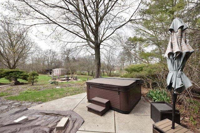 view of patio featuring a storage unit, an outbuilding, and a hot tub