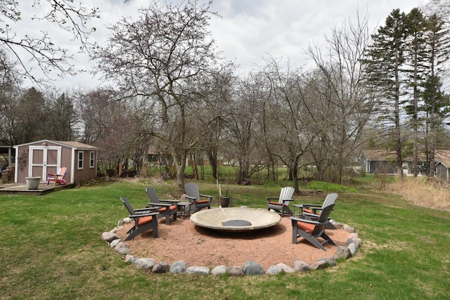 view of yard with a fire pit, an outdoor structure, and a storage shed