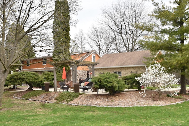 rear view of property with a pergola, a patio, and a lawn