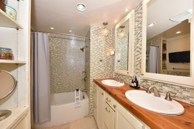 bathroom featuring shower / bath combo with shower curtain, backsplash, and a sink